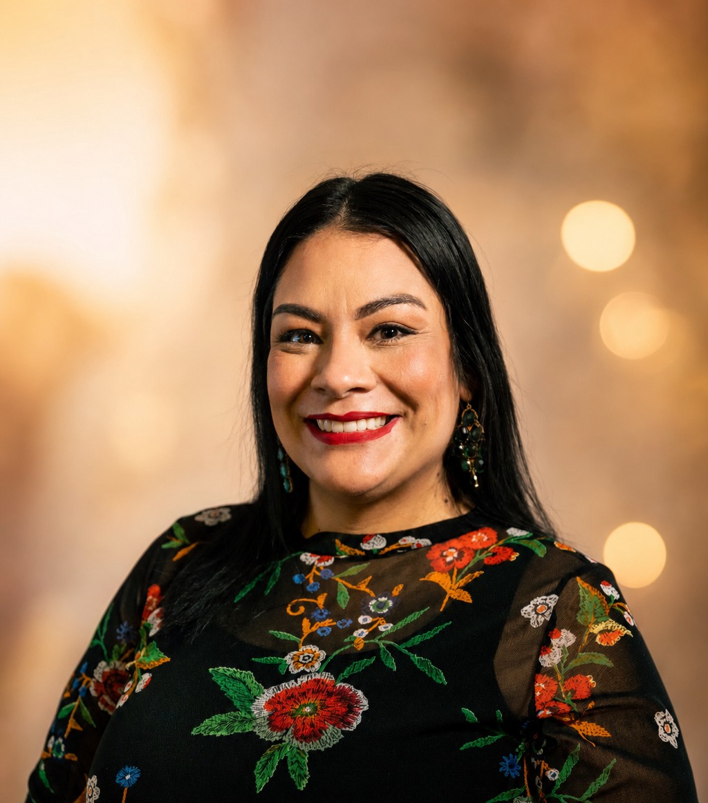 Andrea Nava, founder of Host Grow Your AZ, smiling portrait in an embroidered black top